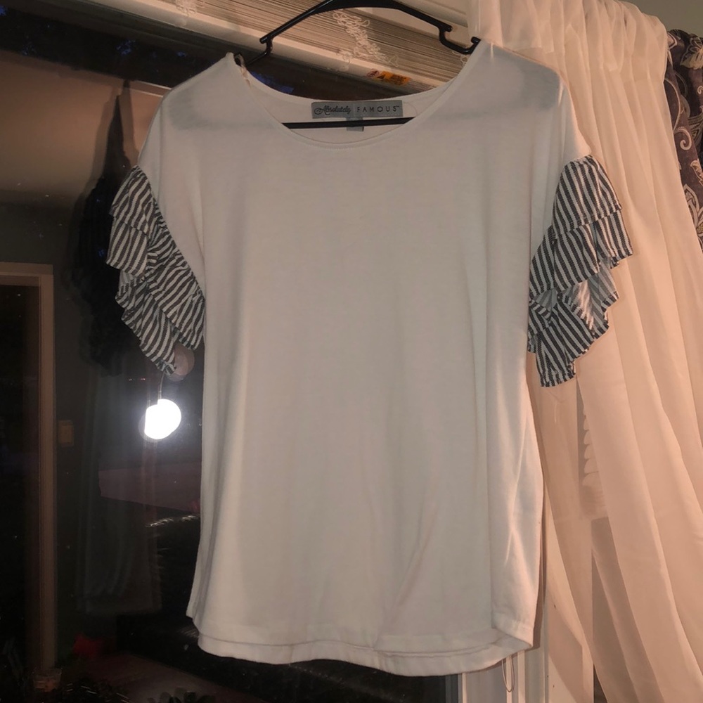 Cute white shirt with navy ruffled sleeves.